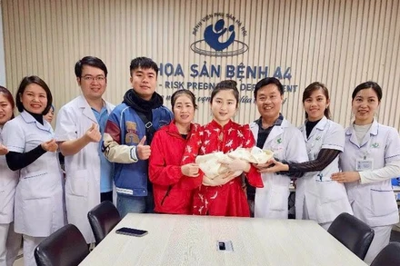 Các nhân viên y tế chúc mừng gia đình sản phụ. 