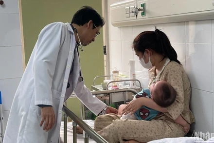 Bác sĩ khám cho bệnh nhi nằm viện do mắc sởi. (Ảnh: HẢI NGÔ)