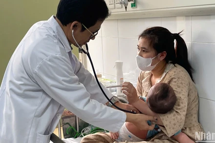 Tiến sĩ, bác sĩ Đỗ Thiện Hải, Phó Giám đốc Trung tâm bệnh Nhiệt đới, Bệnh viện Nhi Trung ương khám cho bệnh nhi mắc sởi. (Ảnh: HẢI NGÔ)