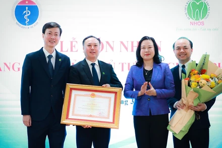 Bộ trưởng Y tế Đào Hồng Lan trao Bằng khen của Thủ tướng Chính phủ cho lãnh đạo Bệnh viện Răng Hàm Mặt Trung ương. (Ảnh: HẢI NGUYỄN)