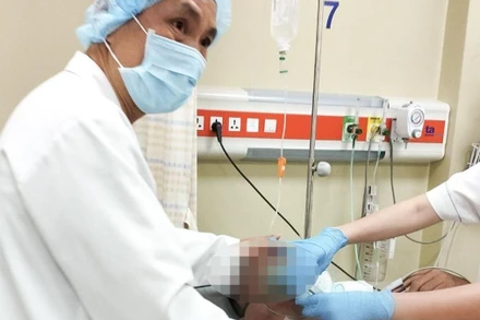 Bác sĩ Trần Minh Giang đang theo dõi nhịp tim của bệnh nhân Singapore. 