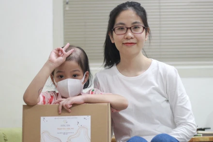 Diệu Thuần và một bé gái nhận được bộ tóc mới. 