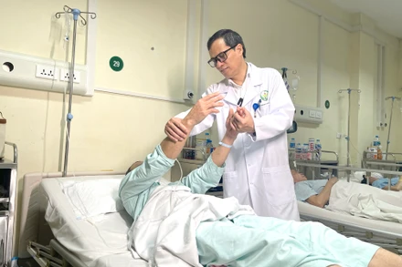 Phó Giáo sư, Tiến sĩ Đồng Văn Hệ thăm khám cho bệnh nhân sau phẫu thuật.