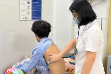 Bác sĩ khám cho nam bệnh nhân mắc lao trẻ tuổi.