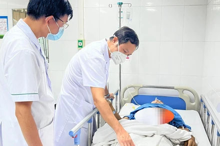 Bác sĩ thăm khám cho người bệnh sau phẫu thuật. 