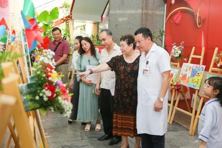 Các đại biểu tham quan triển lãm tranh vẽ của các bạn nhỏ mắc bệnh thalassemia.