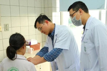 Bác sĩ Ngô Gia Khánh và bác sĩ Nguyễn Văn Minh kiểm tra cho bệnh nhân.
