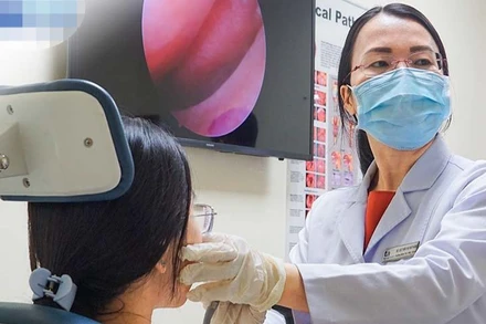 Thạc sĩ, bác sĩ chuyên khoa II Trần Thị Thúy Hằng, Trưởng khoa Tai Mũi Họng, Trung tâm Tai Mũi Họng đang nội soi mũi họng cho một người bệnh.