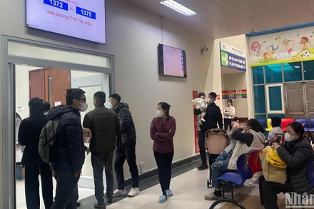 Bố mẹ chờ con tại khu xét nghiệm máu, Bệnh viện Nhi Trung ương. 