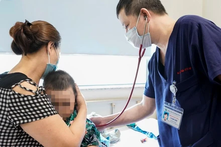 Phó Giáo sư, Tiến sĩ Tạ Anh Tuấn, Trưởng Khoa Điều trị tích cực Nội khoa thăm khám cho bệnh nhi.