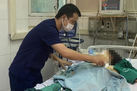 Bác sĩ Hùng khám cho bệnh nhân mắc sốt xuất huyết nguy kịch. 