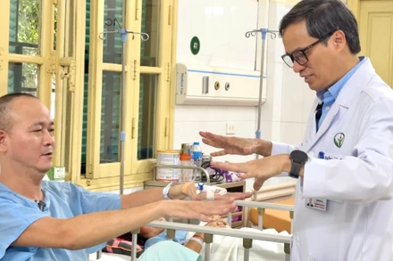 Phó Giáo sư, Tiến sĩ Đồng Văn Hệ kiểm tra chức năng vận động của người bệnh sau mổ.