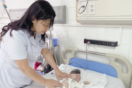 PGS, TS Nguyễn Việt Hoa, Trưởng khoa Phẫu thuật Nhi và Trẻ sơ sinh, Bệnh viện Hữu nghị Việt Đức đang thăm khám cho bệnh nhi.