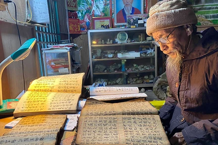 Già Đặng Hành Phi, xã Tân Lập (huyện Chợ Đồn) tự học và sưu tầm tài liệu chữ Nôm Dao. (Ảnh MINH TÂM)