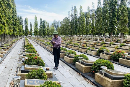 Thầy giáo Nguyễn Sỹ Hồ chụp ảnh bia mộ tại các nghĩa trang liệt sĩ, giúp thân nhân tìm mộ liệt sĩ. (Ảnh NVCC)