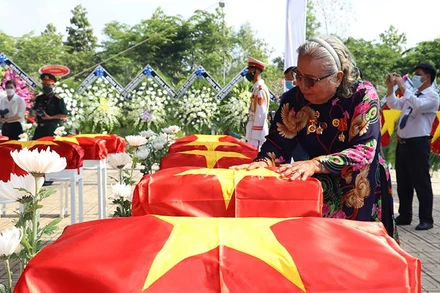 Bà Thân Thị Vân xúc động bên hài cốt đồng đội trong lễ truy điệu tại Nghĩa trang liệt sĩ huyện Nhơn Trạch (Đồng Nai).