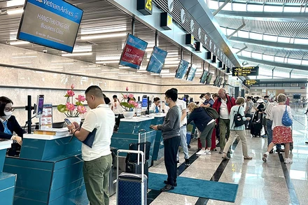 Hành khách làm thủ tục tại quầy của Hãng hàng không quốc gia Việt Nam. (Ảnh BẢO NGÂN)