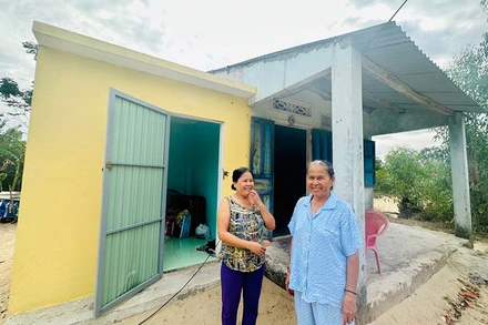 Mẹ con chị Phan Thị Mỹ Nhung ở xã Tam Thanh, thành phố Tam Kỳ bên căn phòng tránh bão.