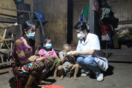 Cán bộ y tế hướng dẫn người dân thôn Phe Phà, xã Lũng Hồ, huyện Yên Minh, Hà Giang uống thuốc điều trị, phòng bệnh bạch hầu.