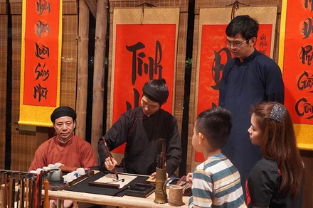 Khách du lịch xin chữ khi tham gia tour đêm tại Văn Miếu - Quốc Tử Giám.