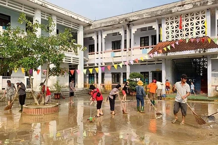 Giáo viên và phụ huynh Trường tiểu học-THCS Hải Hòa (huyện Hải Lăng, tỉnh Quảng Trị) dọn vệ sinh trường lớp để đón học sinh trở lại vào sáng 19/10. (Ảnh QUANG HUY)