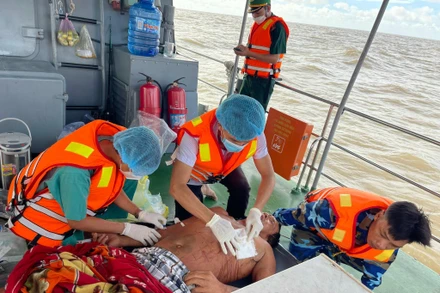 Lực lượng chức năng sơ cứu nạn nhân và đưa vào bờ điều trị. (Ảnh: Đồn Biên phòng Hàm Luông cung cấp).