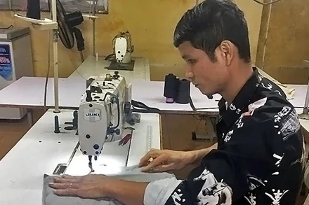 Anh Lường Văn Hiếu, một trong những tấm gương “Tỏa sáng nghị lực Việt”, cần mẫn lao động trên bàn may mỗi ngày.