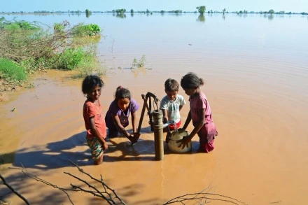 Trẻ em lấy nước sinh hoạt tại khu vực ngập lụt ở Jalandhar, bang Punjab (Ấn Độ). (Ảnh: AFP/TTXVN)