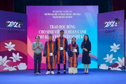 Các nhà tài trợ trao học bổng cho các sinh viên nghèo vượt khó học tập.