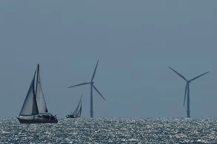 Một chiếc du thuyền đang di chuyển trước một trại điện gió ngoài khơi, nhìn từ Walton-on-the-Naze, miền nam nước Anh. Ảnh: Reuters