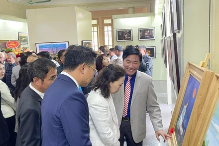 Họa sĩ Nguyễn Văn Trường (thứ 3 bên phải) giới thiệu tranh tại triển lãm.