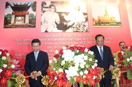 Đồng chí Võ Văn Thưởng (trái) và và đồng chí Sonsay Siphandone cắt băng khai mạc cuộc triển lãm, chiều 17/7.