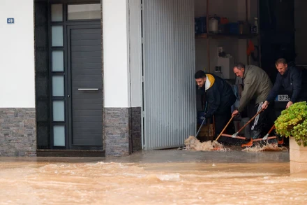 Người dân ngăn chặn nước vào nhà. Ảnh: Reuters.