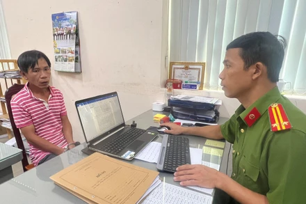 Cán bộ điều tra lấy lời khai nghi can Lê Huy Dũng.