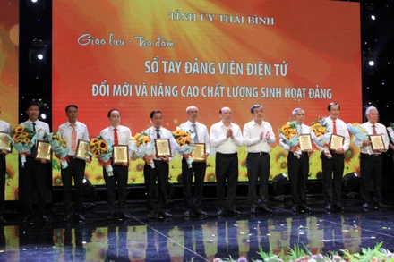 Đồng chí Ngô Đông Hải, Bí thư Tỉnh ủy Thái Bình (thứ 5 từ phải qua) trao biểu trưng vinh danh những tập thể, cá nhân triển khai tốt “Sổ tay đảng viên điện tử”.