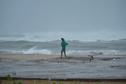 Một người đi dọc bãi biển Neelankarai trong lúc thủy triều lên cao trước khi cơn bão Fengal tiến gần đến Chennai, Ấn Độ. Ảnh: Reuters.