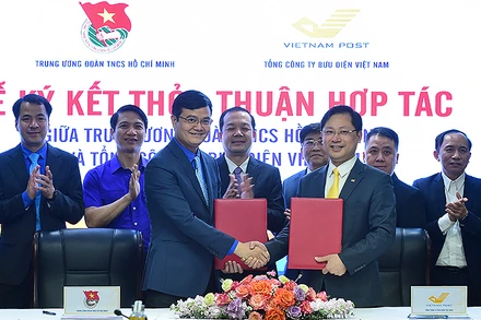 Hàng đầu, từ trái qua: các đồng chí Bùi Quang Huy, Ủy viên dự khuyết Trung ương Đảng, Bí thư thứ nhất Trung ương Đoàn; Chu Quang Hào, Tổng Giám đốc Tổng Công ty Bưu điện Việt Nam trao thỏa thuận hợp tác giữa 2 bên tại buổi lễ.