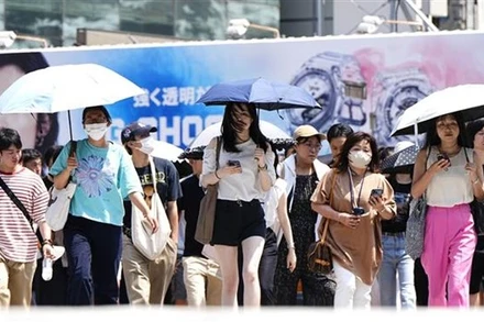 Người dân Tokyo (Nhật Bản) di chuyển dưới trời nắng nóng, ngày 27/7/2023. (Ảnh: Kyodo/TTXVN)
