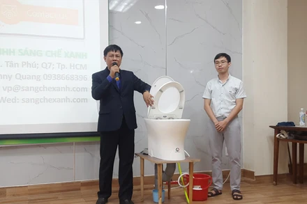 Ông Nguyễn Văn Nam (bên trái ảnh) thuyết trình về nguyên lý hoạt động của sáng chế hệ thống cơ-điện điều khiển bồn cầu xả nước.