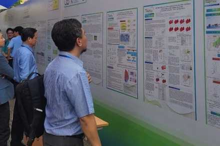Các đại biểu tìm hiểu các báo cáo bằng poster trưng bày tại hội nghị.