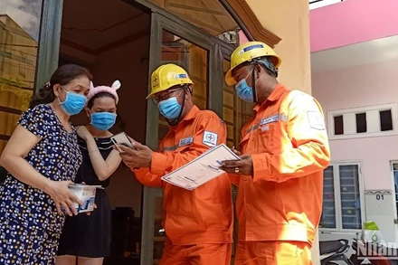 Công nhân ngành điện tuyên truyền cho các gia đình về tiết kiệm điện và giá bán điện theo quy định hiện hành. 