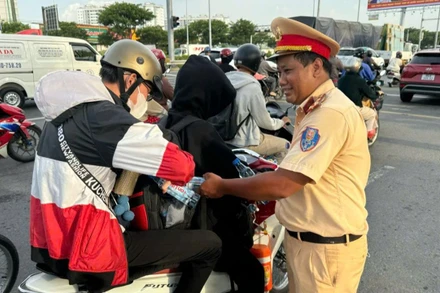 Cảnh sát giao thông Thành phố Hồ Chí Minh phát nước suối miễn phí cho người dân đi đường.