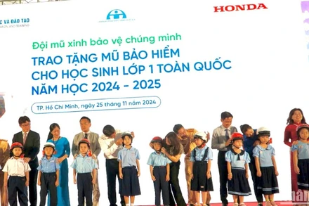 Các đơn vị tổ chức tặng mũ bảo hiểm cho các em học sinh.
