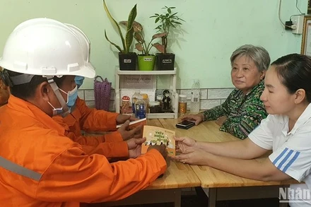Công nhân ngành điện Thành phố Hồ Chí Minh hướng dẫn người dân cách sử dụng điện hiệu quả.