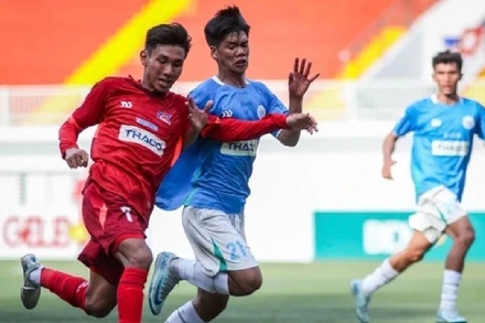 Các cầu thủ đội Trường đại học Tôn Đức Thắng (áo đỏ) trong trận đấu khai mạc chiều nay. (Ảnh: NHẬT THỊNH)