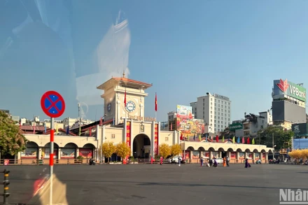Người dân chụp hình, tham quan trước cổng chợ Bến Thành (quận 1) sau kỳ nghỉ Tết. Ảnh: MINH CHÁNH