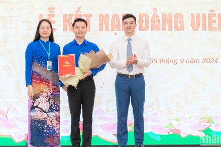 Đồng chí: Nguyễn Thị Hồng, Bí thư Đảng ủy; Nguyễn Anh Tuấn, Đảng ủy viên, Phó Hiệu trưởng Nhà trường trao quyết định và tặng hoa chúc mừng Đảng viên mới tại buổi lễ