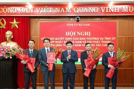 Đồng chí Trương Quốc Huy, Bí thư Tỉnh ủy, Chủ tịch Ủy ban nhân dân tỉnh, Trưởng Đoàn đại biểu Quốc hội tỉnh trao quyết định và tặng hoa chúc mừng Ban Biên tập Báo Hà Nam.