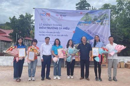 Ông Nguyễn Quang Hưng, Bí thư Huyện ủy Mường Nhé tặng hoa cảm ơn các đơn vị tài trợ hai điểm trường. 