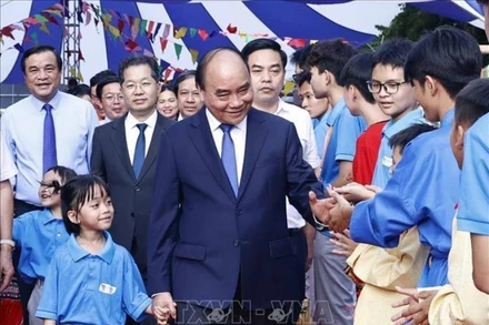 Chủ tịch nước Nguyễn Xuân Phúc với học sinh Trường Tiểu học, Trung học cơ sở và Trung học phổ thông Hy Vọng. (Ảnh TTXVN)